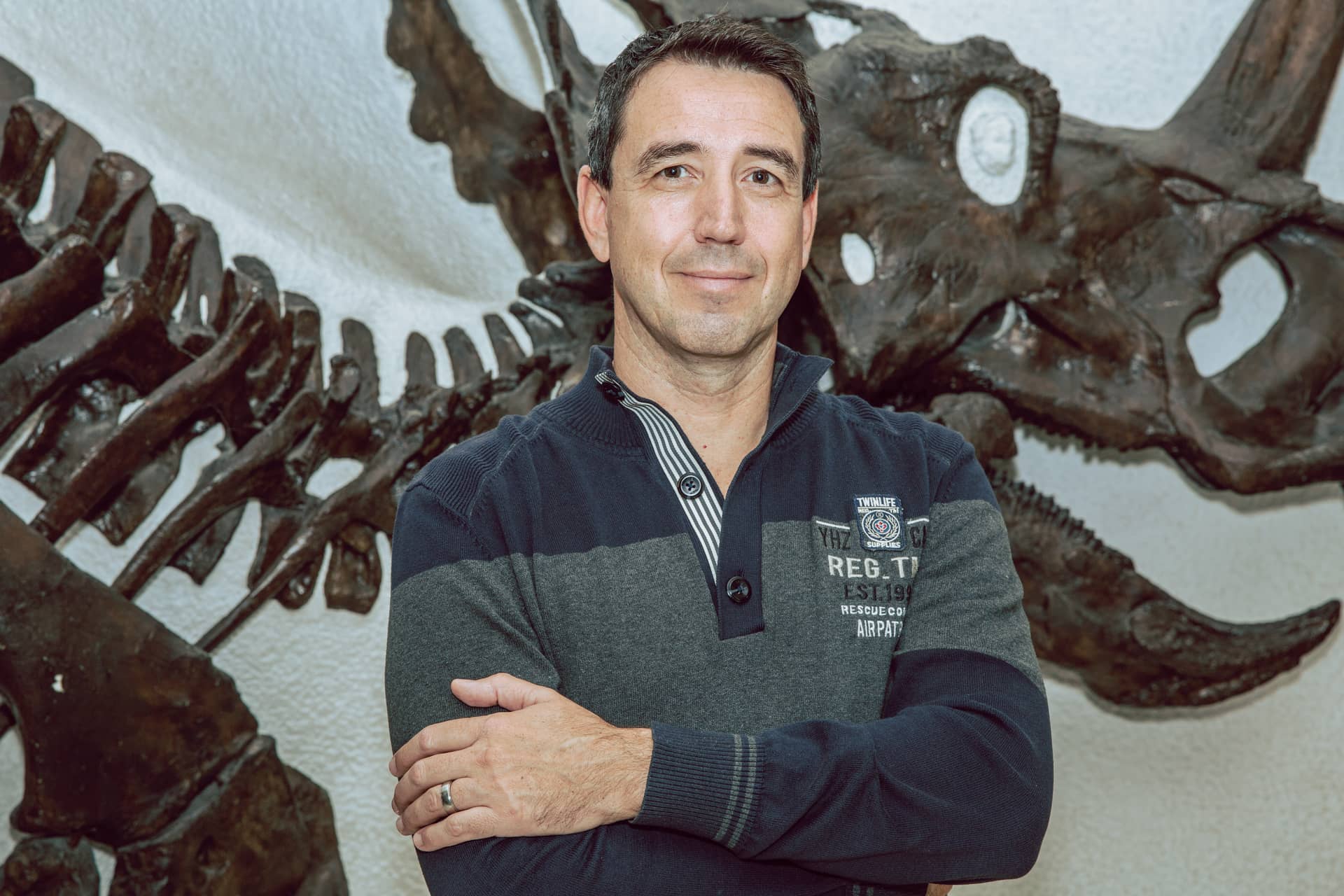 Porträt von Uwe Laub vor Dinosaurierskelett im Paläontologischen Museum München / Hintergrundinformationen zu LEBEN